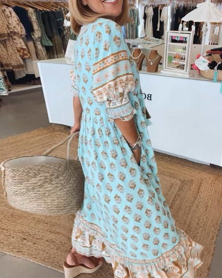 A woman wearing the Patricia boho floral midi dress with a fringed neckline and ruffled skirt.