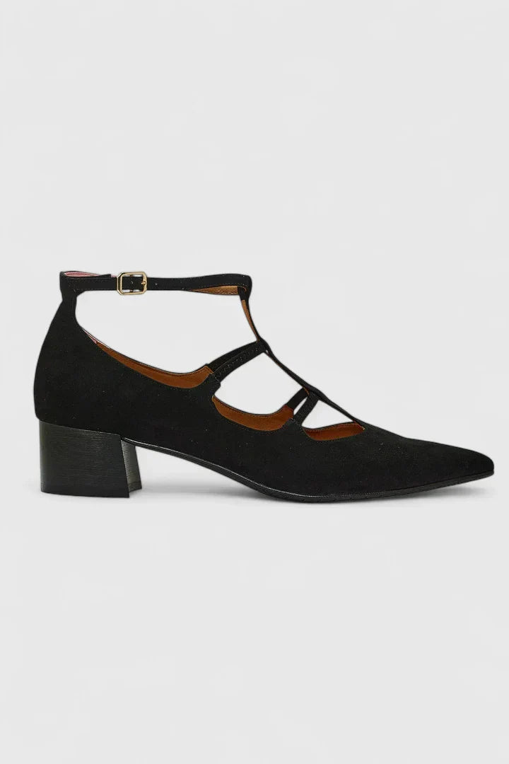 A woman standing gracefully in low wide-fit comfort heels with a cushioned footbed.
