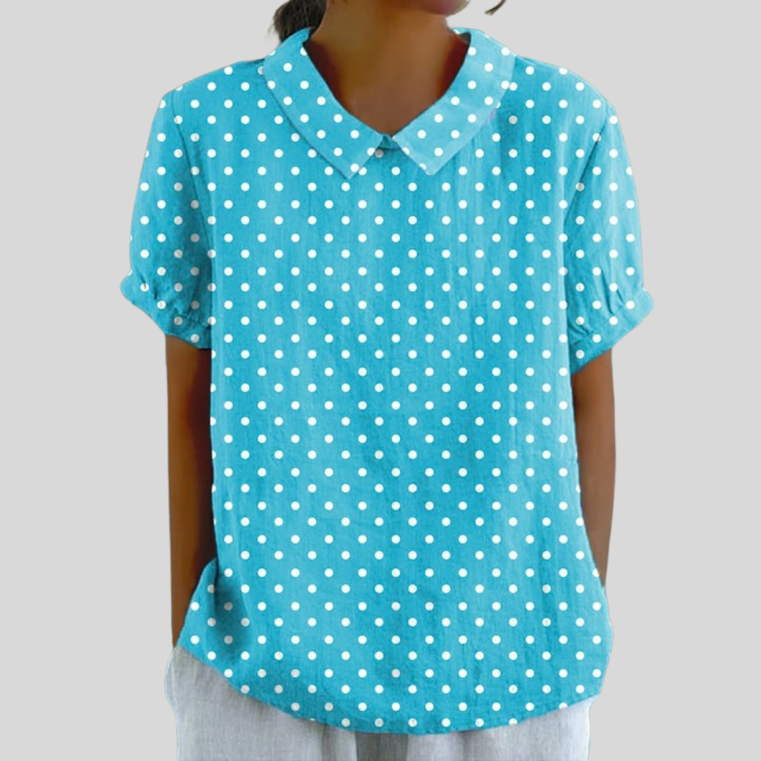 A woman wearing a soft floral top with a structured polo collar, looking feminine and elegant.