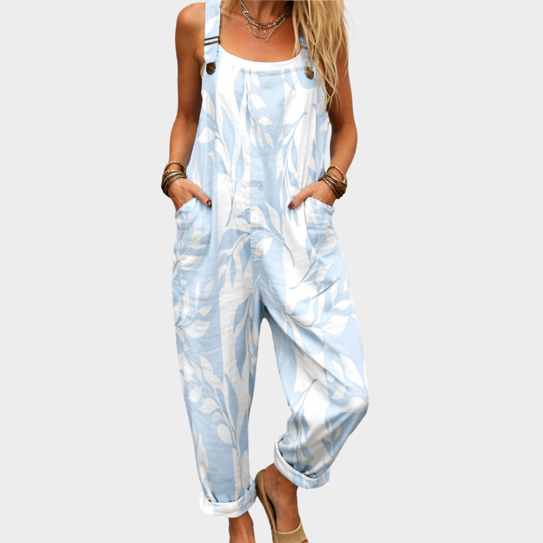 Woman wearing light blue and white leaf-print dungarees with adjustable straps, fresh and relaxed.