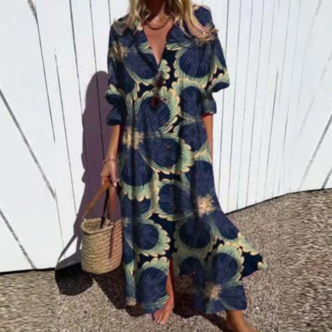 Woman wearing the Zara™ leaf print maxi dress with a button front, walking along the coast in a light breeze.