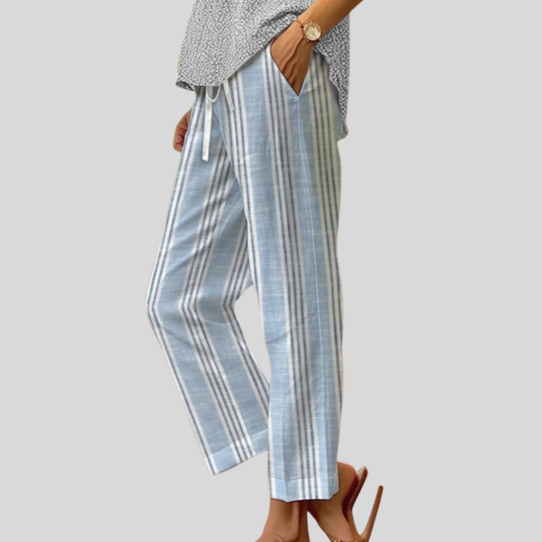 Woman wearing flowing everyday trousers with a soft top and sandals in daylight.