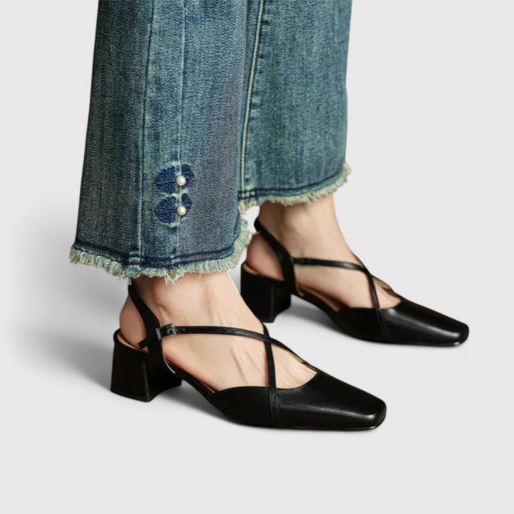 A woman wearing beige chic block heel sandals with an adjustable strap at an evening event.