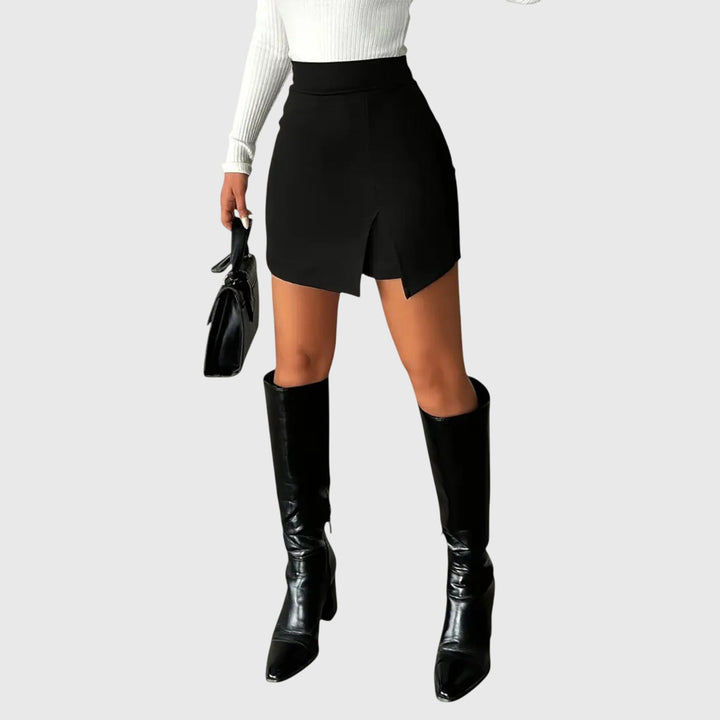 A woman wearing a sleek high-waisted black pencil skirt with a hem slit.