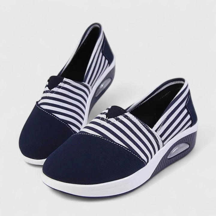 A woman wearing blue striped orthopaedic trainers on a walk