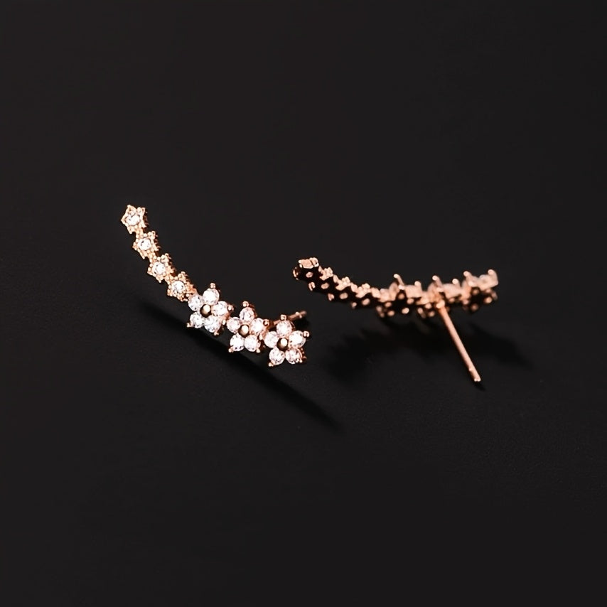 Rose gold floral crawler earrings with delicate sparkling floral motif following the curve of the ear