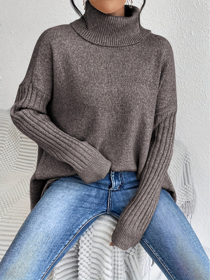 A woman wearing a stand-collar jumper with a chic asymmetric drape, warm and polished.