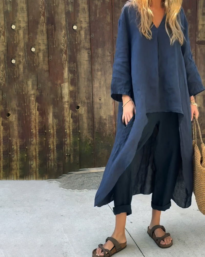 A woman wearing a blue asymmetric tunic with wide-leg trousers
