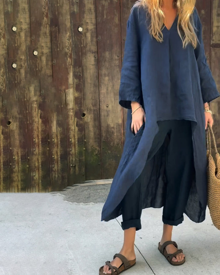 A woman wearing a blue asymmetric tunic with wide-leg trousers