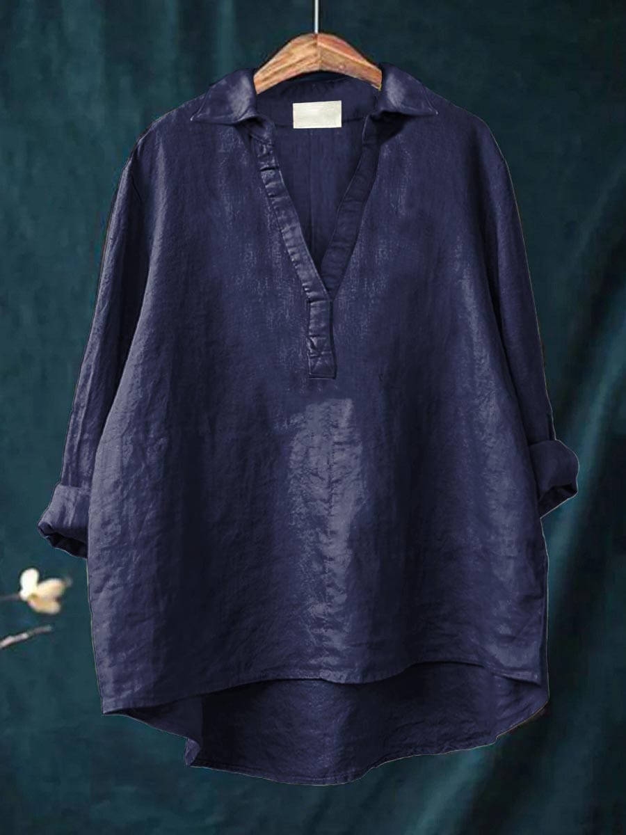 A woman wearing an elegant solid-colour summer blouse with an open V-neck, looking fresh and stylish on a warm day.