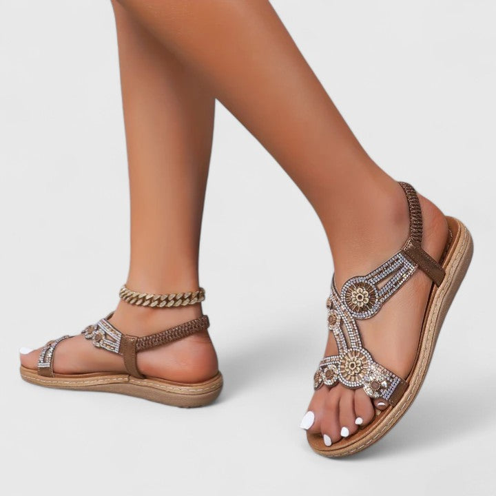 A woman walking with ease in brown wide-fit comfort sandals with an adjustable strap.