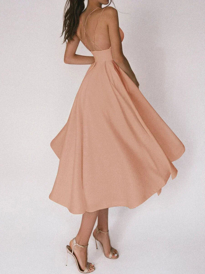 Woman at a summer celebration wearing the Katie minimalist maxi dress with fine double straps and a floating skirt.
