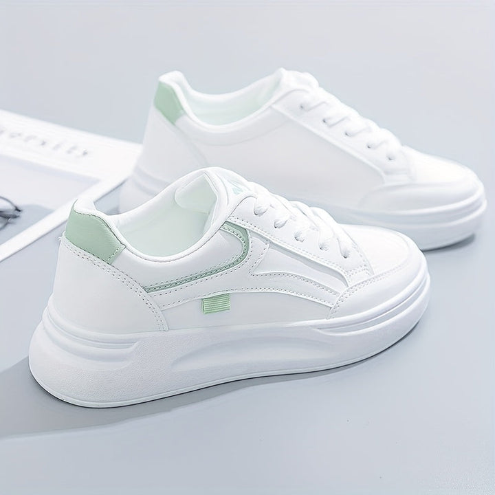 A woman in crisp white light comfort trainers paired with jeans.