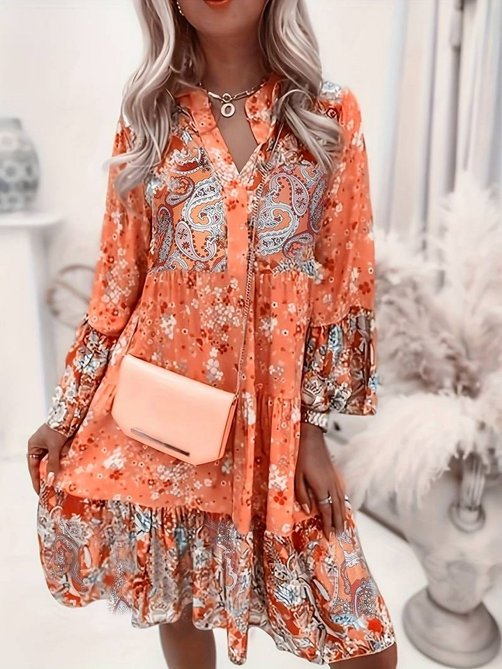 Woman in a relaxed boho dress with a colourful paisley and floral print.