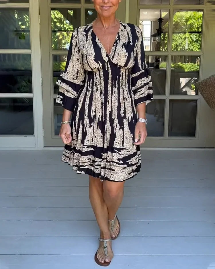 Woman wearing a boho print mini dress with ruffled sleeves and a soft V-neckline.