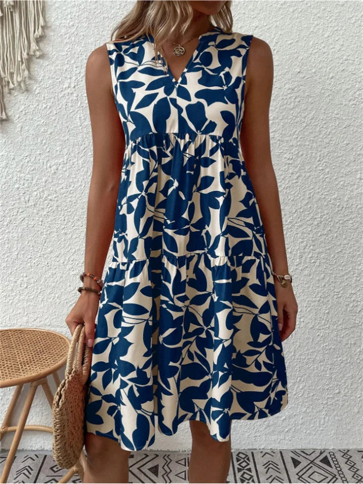Woman wearing the Eileen sleeveless floral midi dress, relaxing outdoors on a warm afternoon.