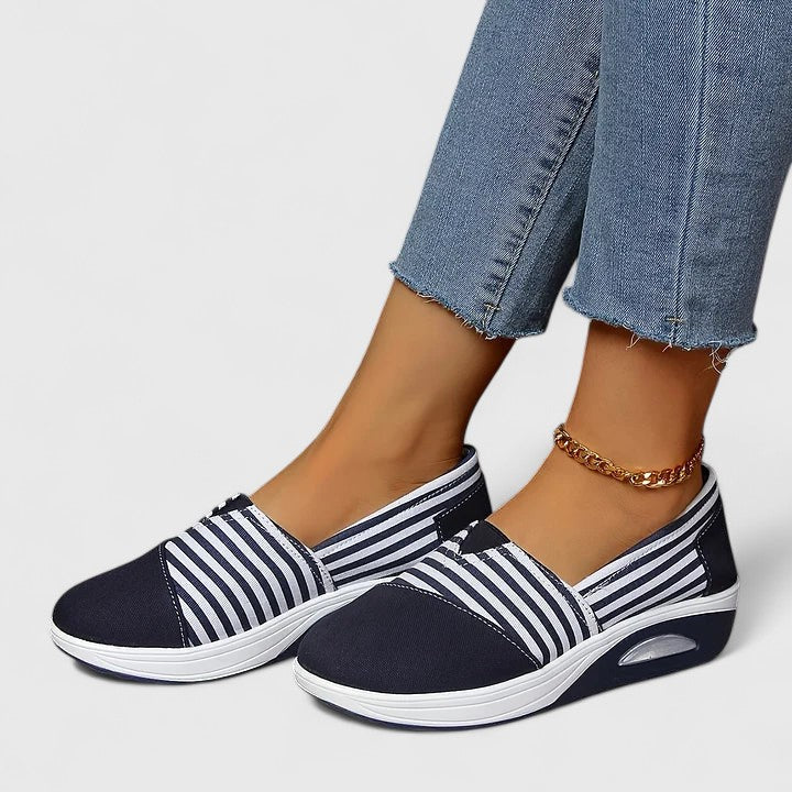 A woman wearing blue striped orthopaedic trainers on a walk