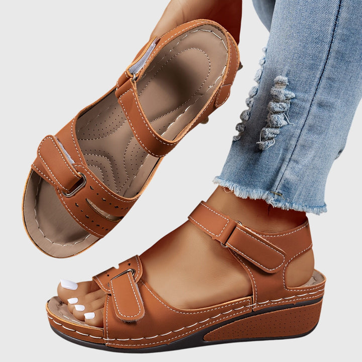 A woman wearing wide-fit supportive sandals with a relaxed summer outfit, walking with ease and confidence.