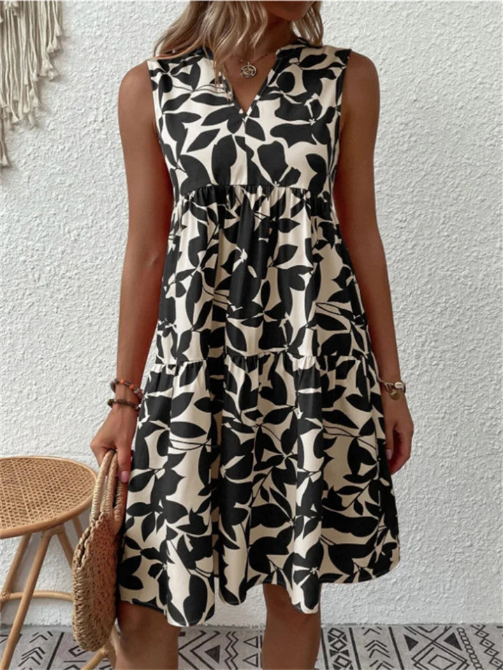 Woman wearing the Eileen sleeveless floral midi dress, relaxing outdoors on a warm afternoon.