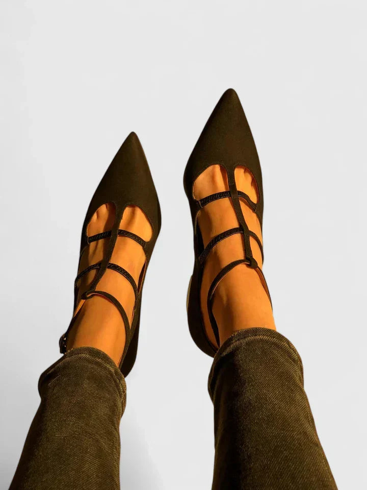A woman standing gracefully in low wide-fit comfort heels with a cushioned footbed.