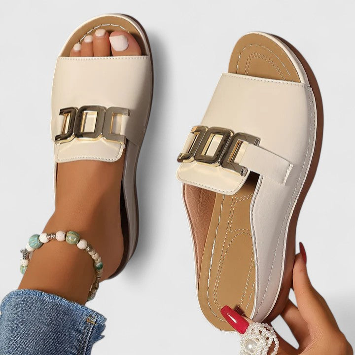 A woman walking easily in grey supportive sandals with a cushioned sole and adjustable strap.