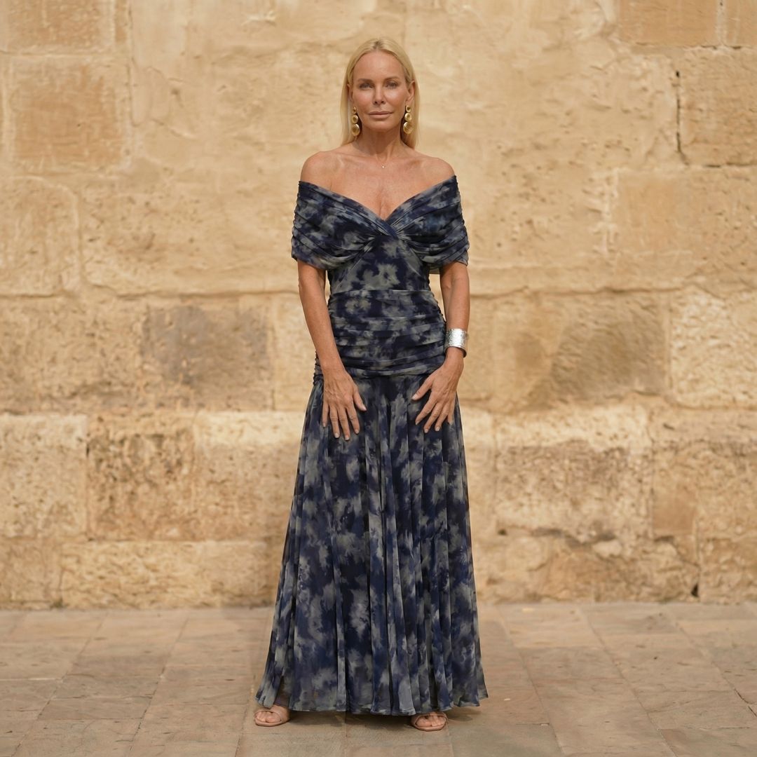 A woman wearing an elegant flowing navy dress at an evening occasion.