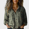 Olive green long-sleeve blouse with a subtle floral print and classic front button detail