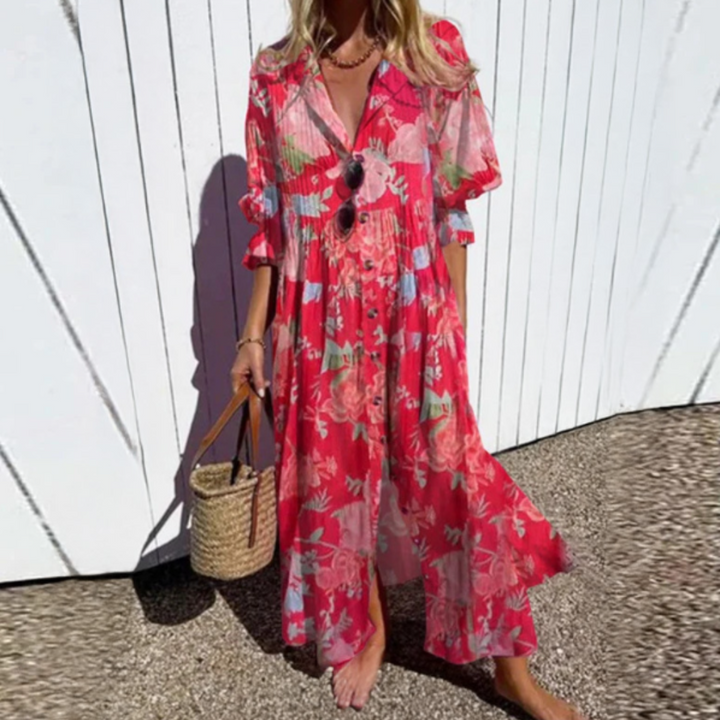 Woman wearing the Zara™ leaf print maxi dress with a button front, walking along the coast in a light breeze.