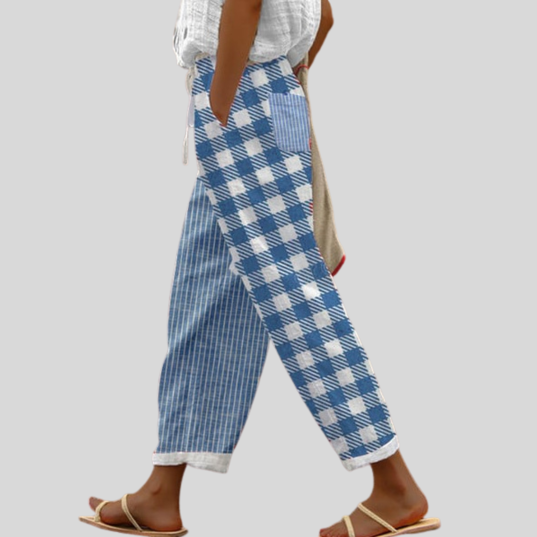 Woman wearing relaxed everyday trousers with a soft blouse and sandals at home.