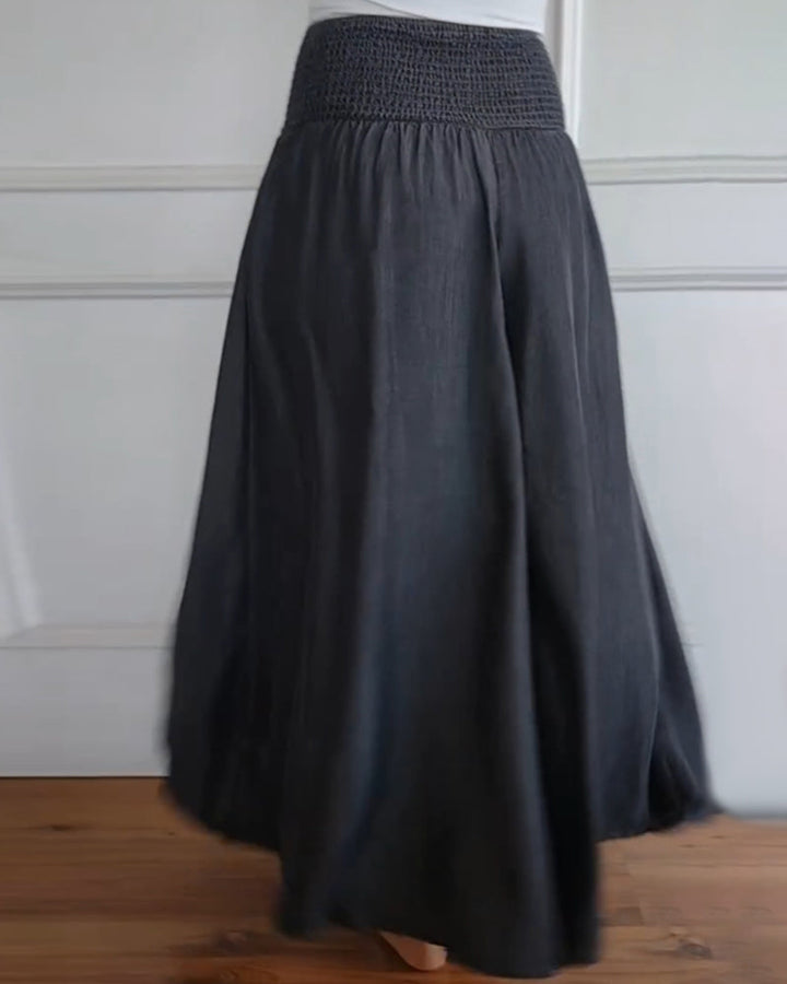 Woman wearing high-waist wide-leg trousers with a tucked-in blouse, mid-stride.