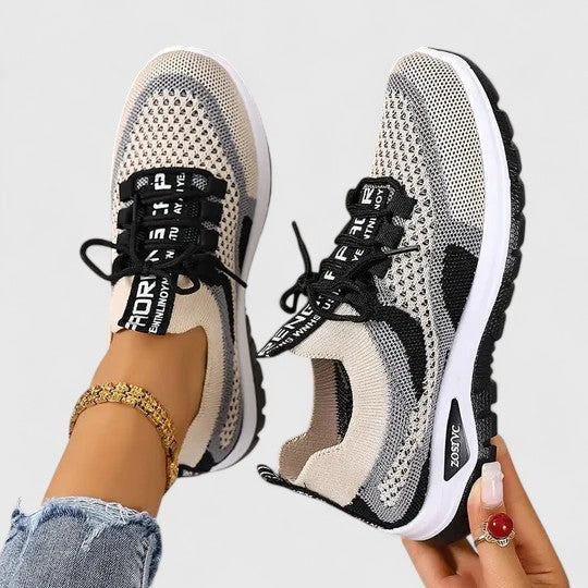 A woman lacing up light, breathable orthopaedic trainers before a walk.