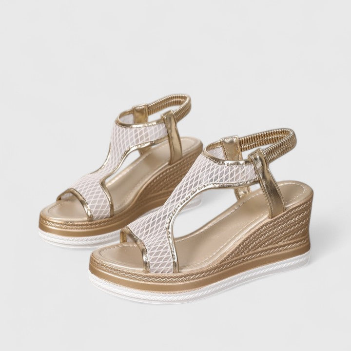 A woman wearing beige chic sandals with a cushioned sole and adjustable strap.