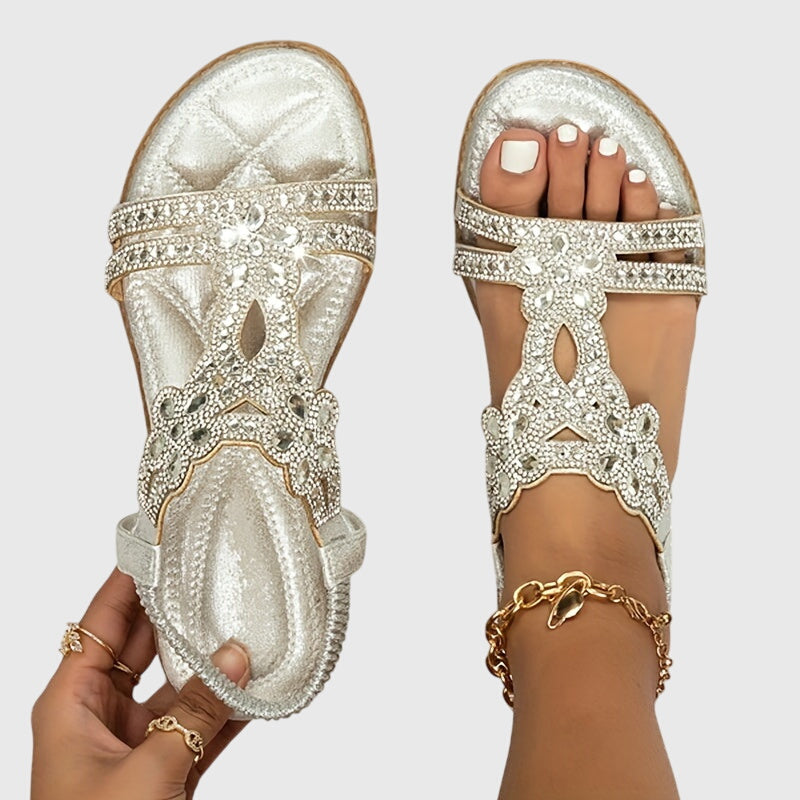 A woman wearing elegant gold open-front sandals with supportive straps and a cushioned sole.