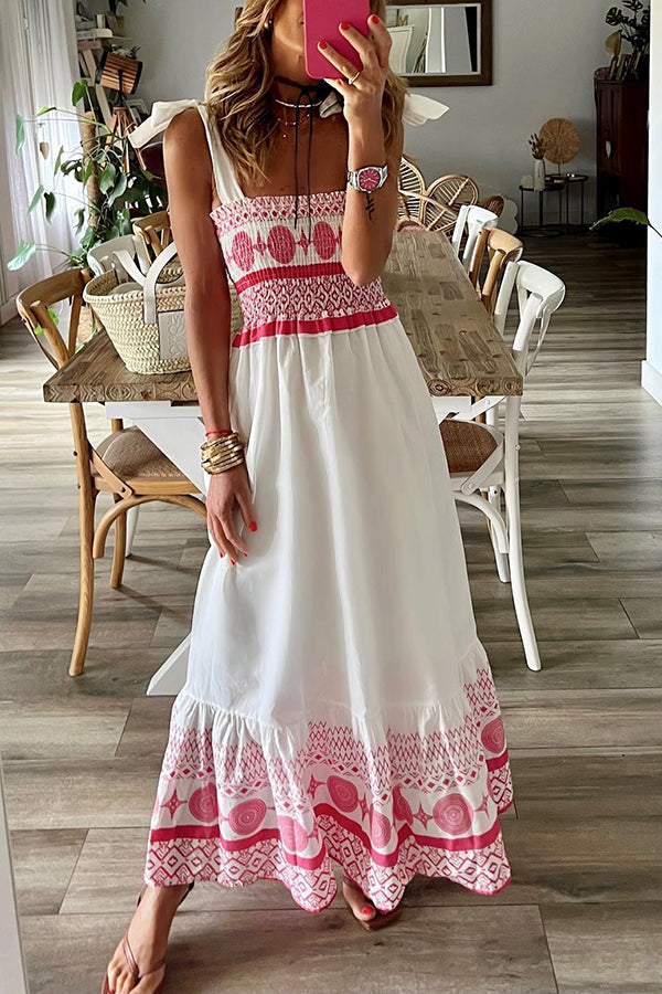 Woman wearing the Teresa™ boho print maxi dress with a gathered bodice, enjoying a warm summer day outdoors.