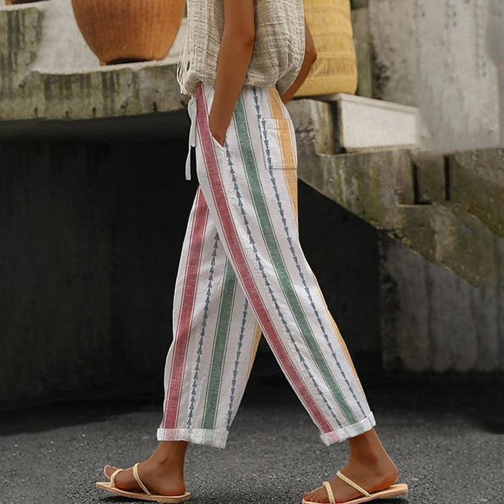 A woman wearing colourful vertical-striped casual trousers with a straight leg and elastic waist.