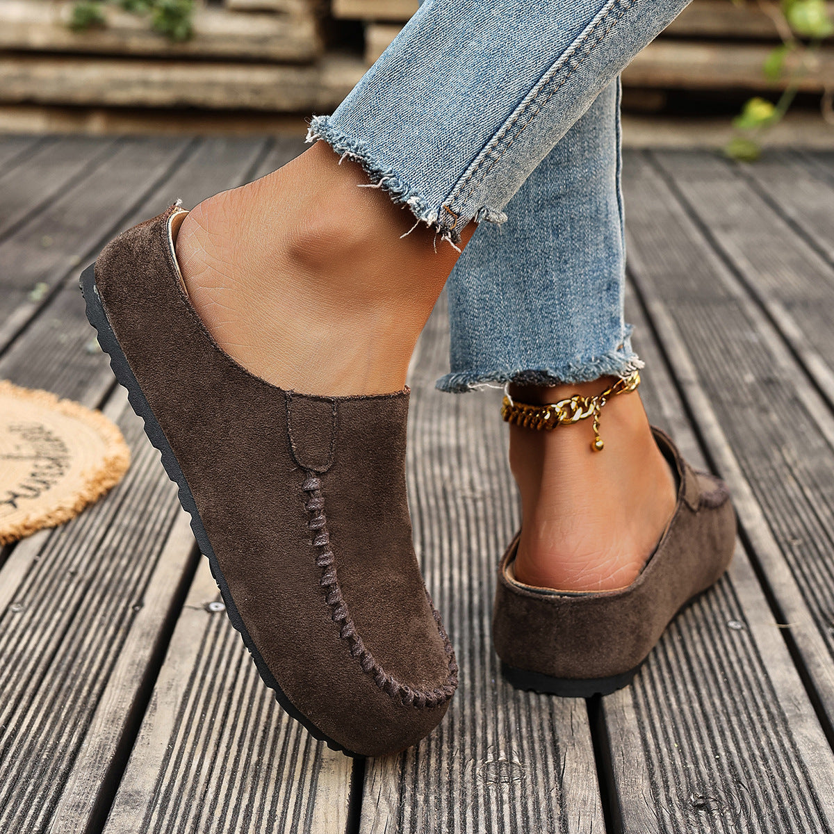 A pair of minimal slip-on loafers in warm brown with a soft footbed and open back