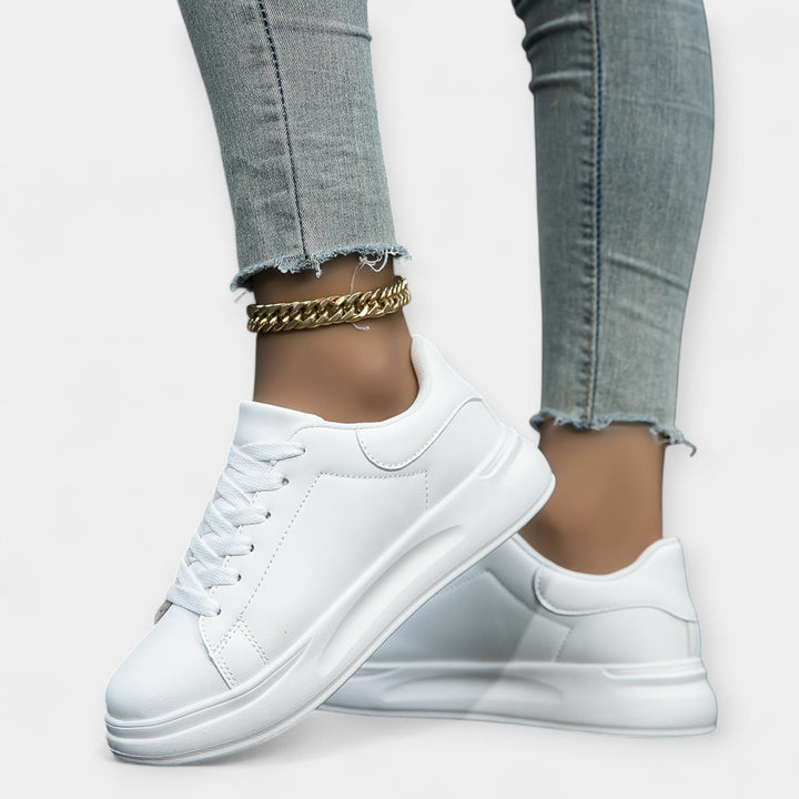 Women's classic white trainers with a clean minimal design and cushioned support sole
