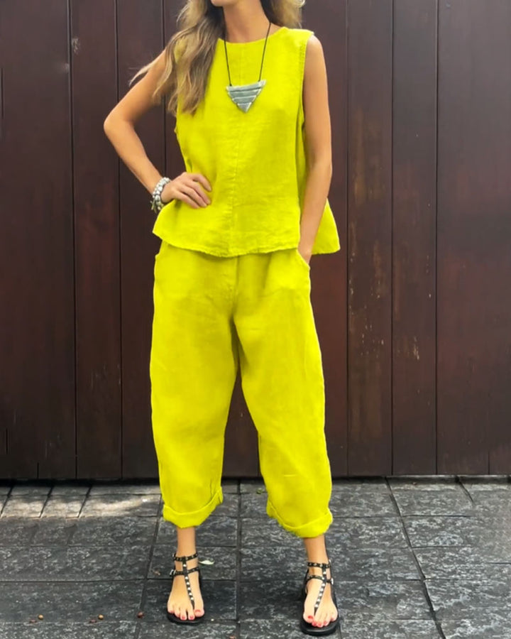 A woman wearing a relaxed sleeveless top with ankle-length trousers, easy and elegant.
