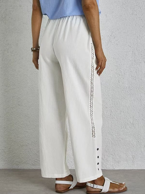 Woman wearing relaxed button-detail trousers with a simple top, out for the day.