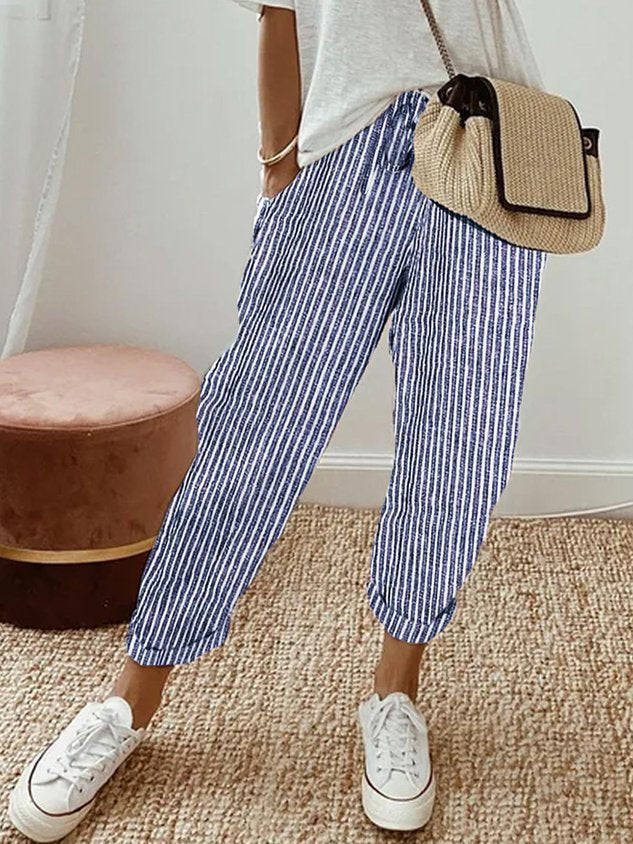 A woman wearing flowing elegant trousers with a soft elastic waist and deep pockets.