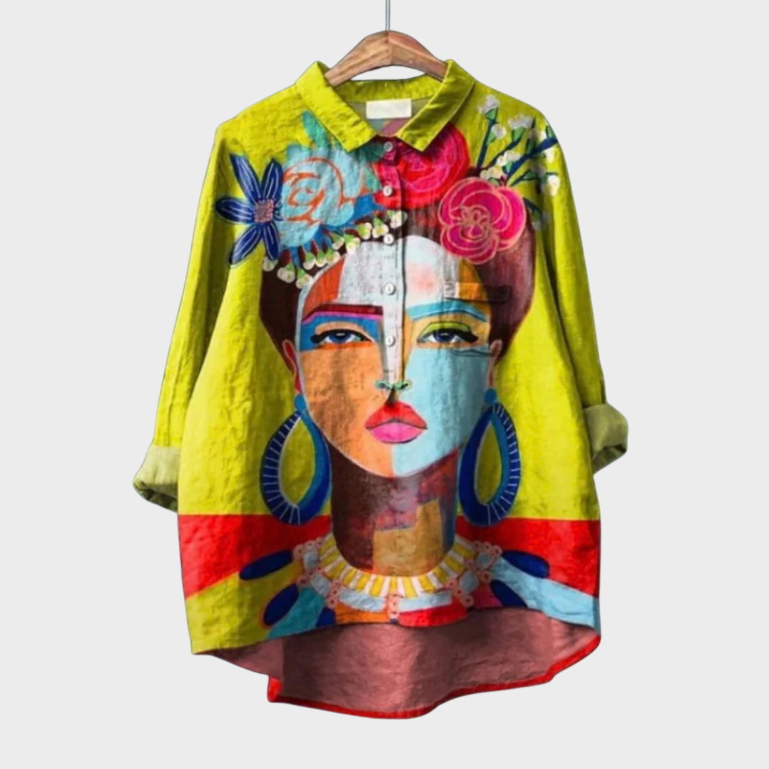 Woman wearing a yellow summer blouse with a bold artistic painted face print.
