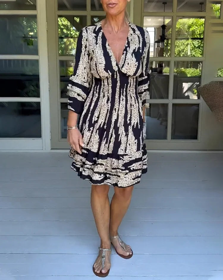Woman wearing a boho print mini dress with ruffled sleeves and a soft V-neckline.