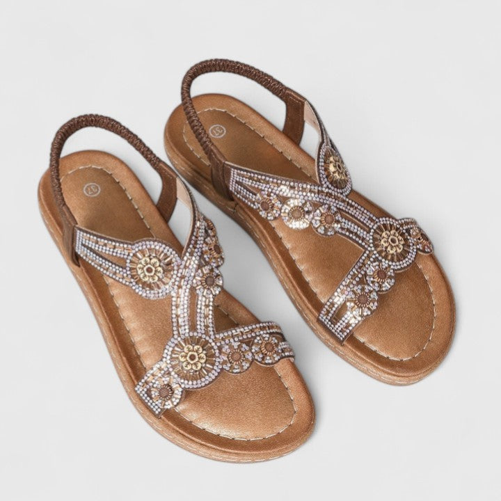 A woman walking with ease in brown wide-fit comfort sandals with an adjustable strap.