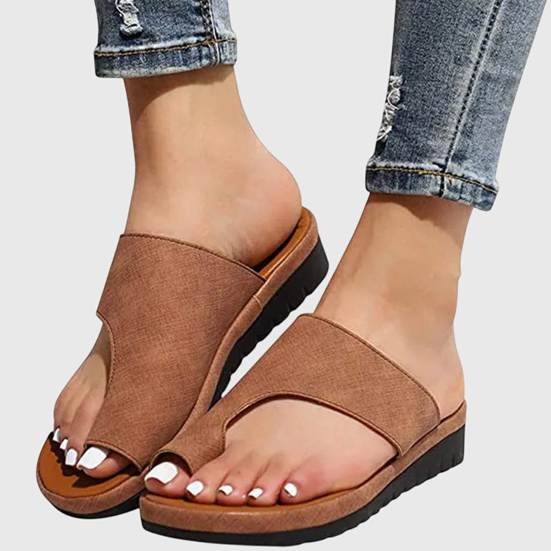 A woman in gold supportive sandals standing gracefully, feet cushioned and at ease.
