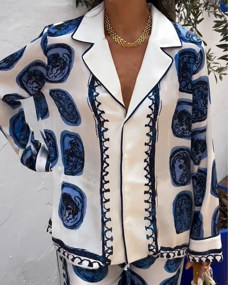 A woman wearing a blue-and-white printed open-collar shirt and matching straight-leg trousers on a warm summer day