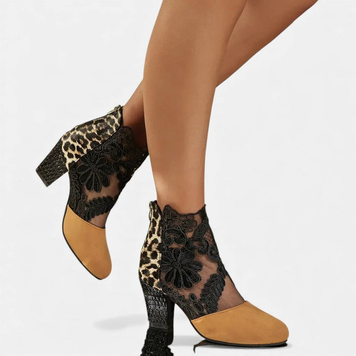 A woman wearing wide-toe orthopaedic heels, standing comfortably in an elegant everyday look.