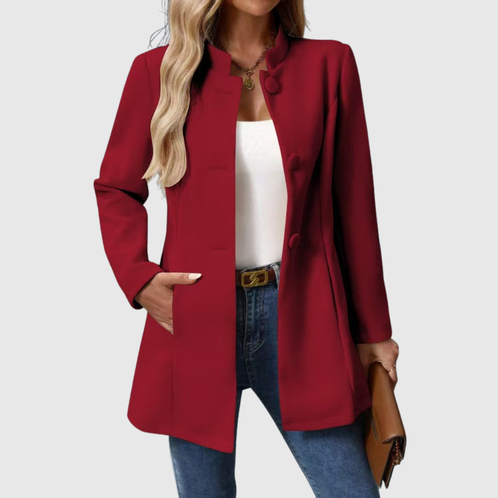 A woman wearing a collarless tailored jacket with a button front