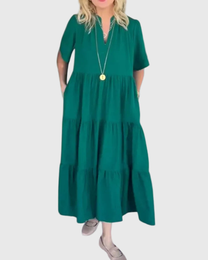 Woman wearing the Kate maxi dress with her hands resting in its side pockets.