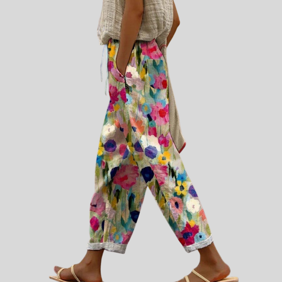 Woman wearing relaxed everyday trousers with a light top and sandals in daylight.
