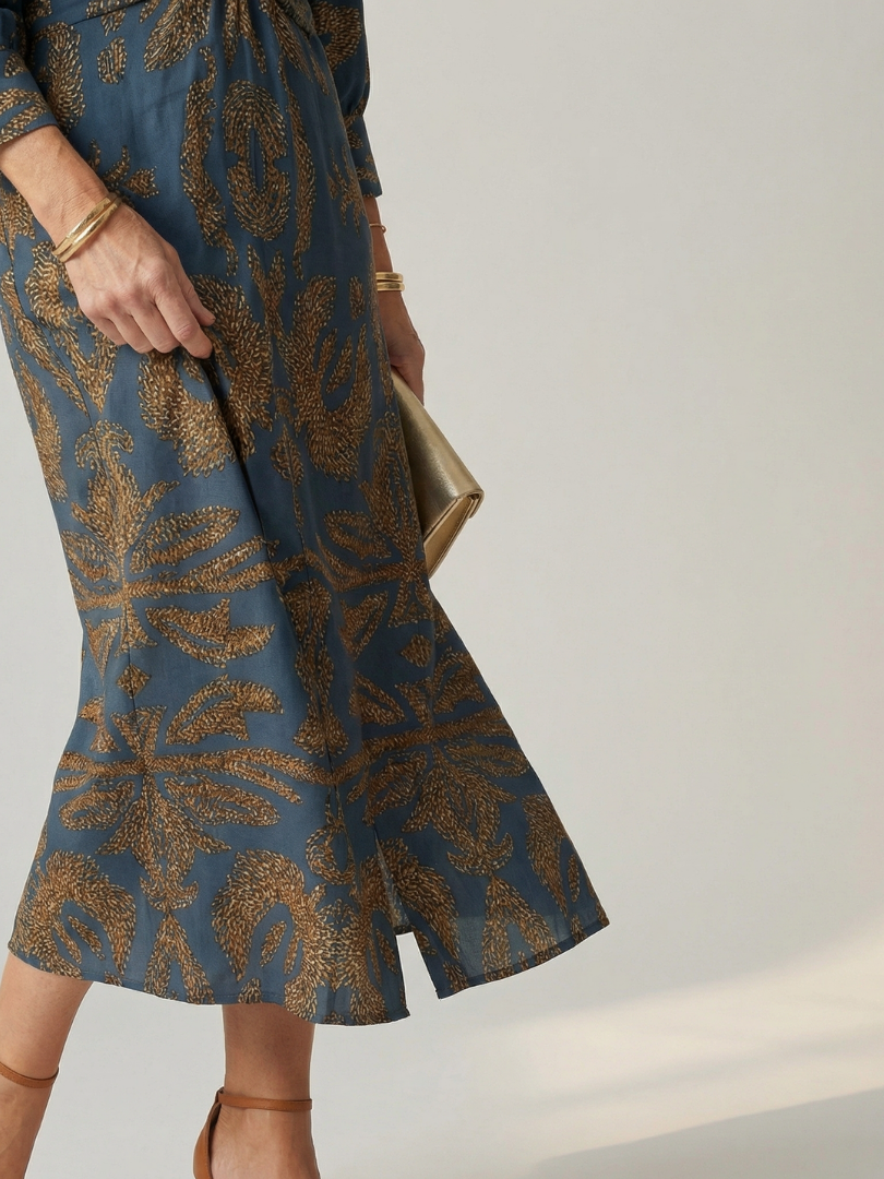 Dark green long-sleeve midi dress with diagonal wrap bodice and straight skirt in a detailed print